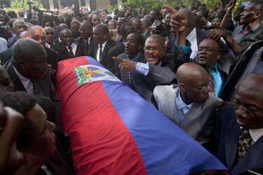 Friends and family of Haiti's late Dictator Jean-Claude "Baby Doc" Duvalier carry his flag draped coffin back to the funeral home after his funeral ceremony in Port-au-Prince, Haiti, Saturday, Oct. 11, 2014. Many had wondered whether the self-proclaimed "president for life" would receive a state funeral following his death last Saturday from a heart attack at age 63. However, friends and family held a simple and private funeral. (AP Photo/Dieu Nalio Chery)