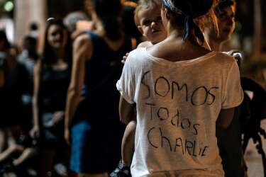 A woman takes part in a rally to show solidarity for the victims of the attack on the offices of France's satirical weekly Charlie Hebdo, in Rio de Janeiro, Brazil on January 7, 2015. Cities and towns worldwide staged vigils late Wednesday in solidarity with the French people after the massacre by Islamist gunmen in Paris against a satirical paper left at least 12 dead.  AFP PHOTO / YASUYOSHI CHIBA