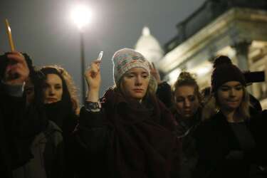 People raise pens during a vigil to pay tribute to the victims of a shooting by gunmen at the offices of weekly satirical magazine Charlie Hebdo in Paris, at Trafalgar Square in London January 7, 2015. Hooded gunmen stormed the Paris offices of a satirical magazine known for lampooning Islam and other religions on Wednesday, killing at least 12 people in the most deadly militant attack on French soil in decades. REUTERS/Suzanne Plunkett (BRITAIN - Tags: POLITICS CRIME LAW CIVIL UNREST MEDIA)