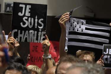 People hold signs reading "I am Charlie" during a demo in tribute to the 17 victims of a three-day killing spree in Paris by homegrown Islamists, outside the French Embassy in Buenos Aires, on January 11, 2015. The tribute took place in support of the Paris rally in which more than a million people flooded Paris on Sunday against terrorism, led by dozens of world leaders walking arm in arm as cries of "Freedom" and "Charlie" rang out. The killings began on January 7 with an assault on the Charlie Hebdo satirical magazine in Paris. AFP PHOTO / ALEJANDRO PAGNI