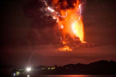 This view from Frutillar, southern Chile, shows a high column of ash and lava spewing from the Calbuco volcano, on April 23, 2015. Chile's Calbuco volcano erupted on Wednesday, spewing a giant funnel of ash high into the sky near the southern port city of Puerto Montt and triggering a red alert. Authorities ordered an evacuation for a 10-kilometer (six-mile) radius around the volcano, which is the second in southern Chile to have a substantial eruption since March 3, when the Villarrica volcano emitted a brief but fiery burst of ash and lava. AFP PHOTO/FRANCISCO NEGRONI