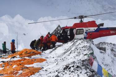 TOPSHOTS
An injured person is loaded onto a rescue helicopter at Everest Base Camp on April 26, 2015, a day after an avalanche triggered by an earthquake devastated the camp. Rescuers in Nepal are searching frantically for survivors of a huge quake on April 25, that killed nearly 2,000, digging through rubble in the devastated capital Kathmandu and airlifting victims of an avalanche at Everest base Camp.  The bodies of those who perished lie under orange tents.  AFP PHOTO/ROBERTO SCHMIDT